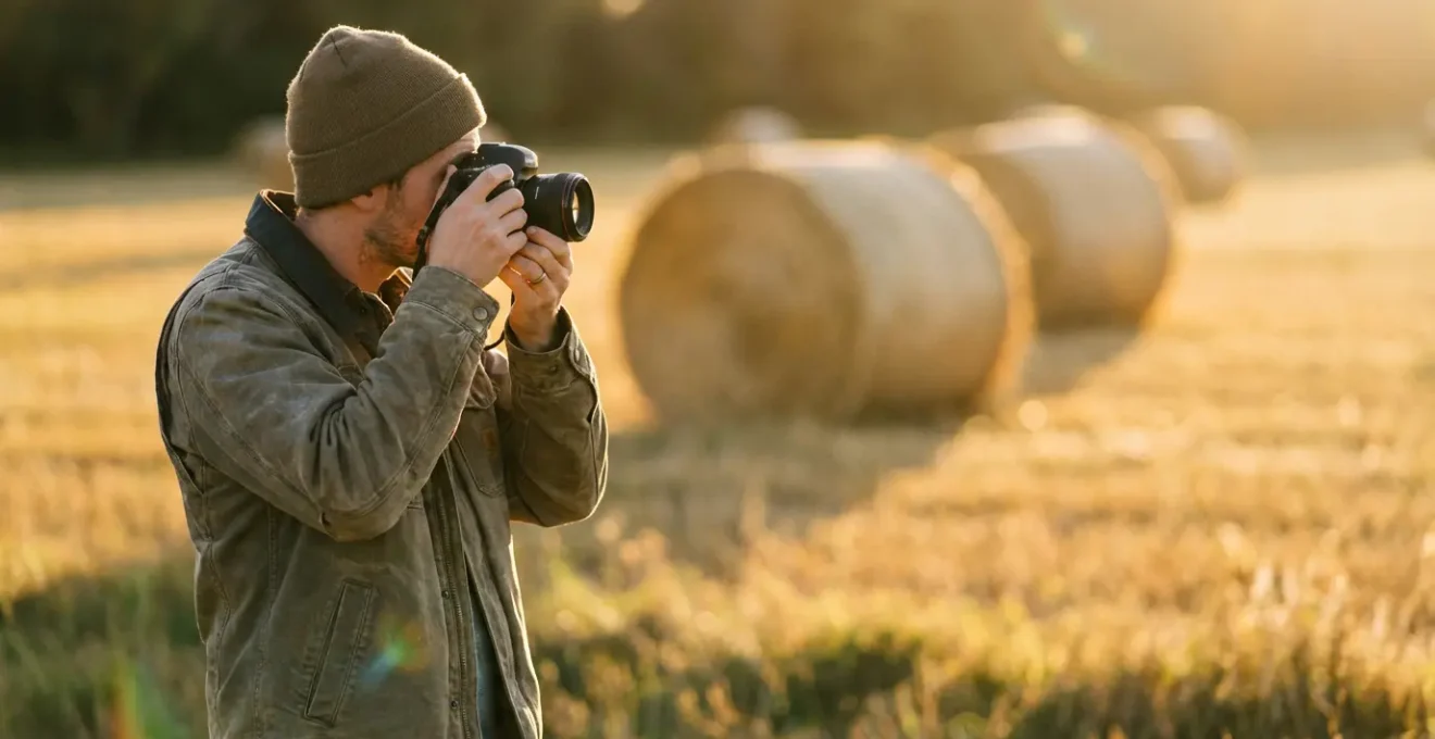 Photographe amateur prenant des photos depuis le bord du champ sans y pénétrer